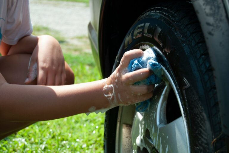 person washing vehicle tire